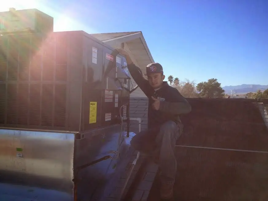 HVAC technician performing AC Tune-Up on a rooftop unit in Sedona